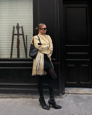 woman wearing neutral outerwear outfit with mini skirt