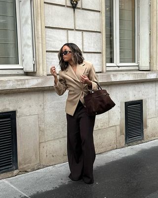 woman wearing neutral outerwear outfit with brown trousers