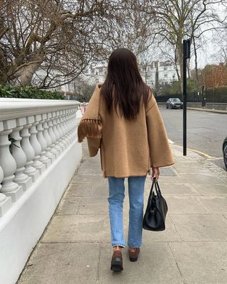 woman wearing neutral outerwear outfit with jeans