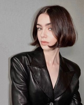 @lilyjcollins with a blunt, bouncy bob hairstyle