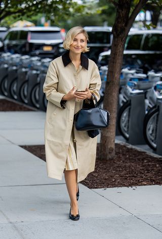 Woman wearing a tan car coat.