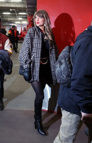 taylor swift wearing black outfit and knee high boots at chiefs game