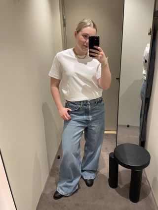 Woman wears white t-shirt, blue jeans and loafers