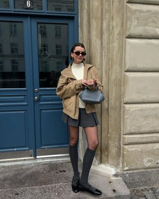 @maryljean wears a pinstripe skirt, white cable knit, canvas jacket and ballet flats