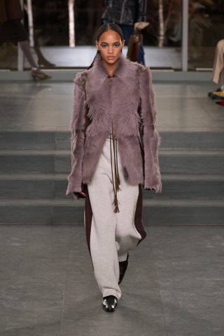 A runway model wears a F/W 2025 Tory Burch outfit.