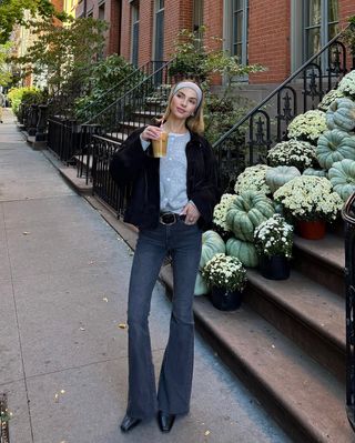 woman wearing flare jeans and belt with black jacket