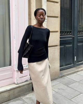 French fashion influencer @sylviemus_ wearing a chic outfit featuring staple Parisian fashion items for 2025, including a boat-neck top.