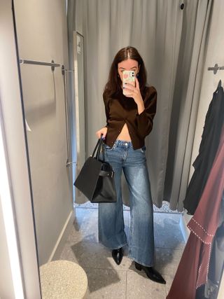 Woman wears brown cardigan and blue jeans