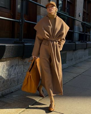 Elsa Hosk wearing a whole camel outfit, including a baseball cap, turtleneck, long belted coat, socks, and shoes.