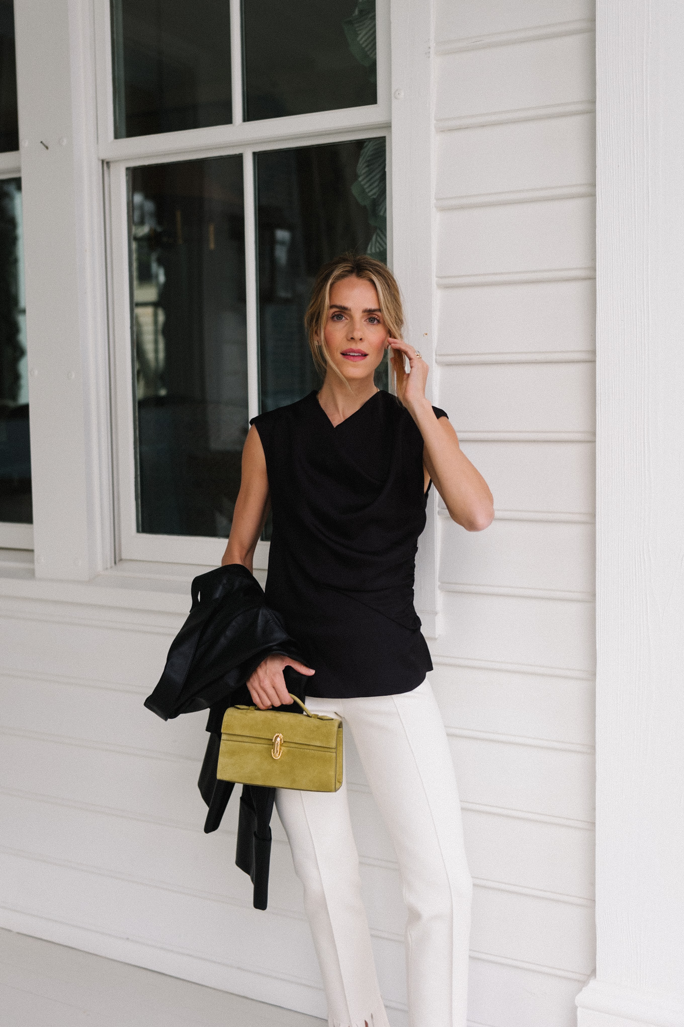 black blouse black leather jacket white fringe trousers black pumps chartreuse handbag