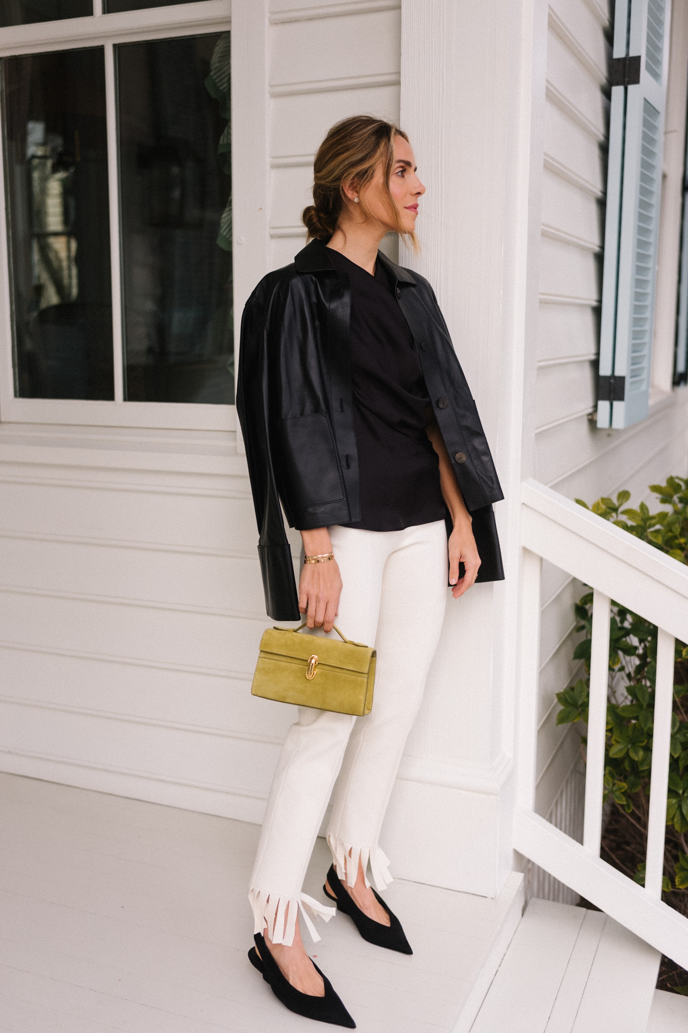 black blouse black leather jacket white fringe trousers black pumps chartreuse handbag