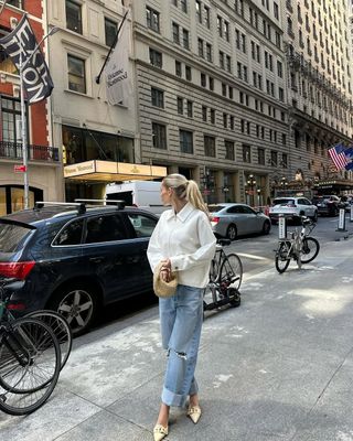 woman wearing cuffed denim outfit with white jacket