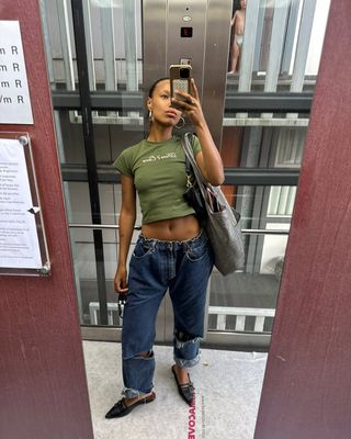 woman wearing cuffed denim outfit with green baby tee