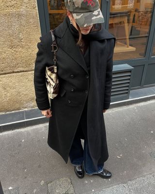 woman wearing cuffed denim outfit with long black coat