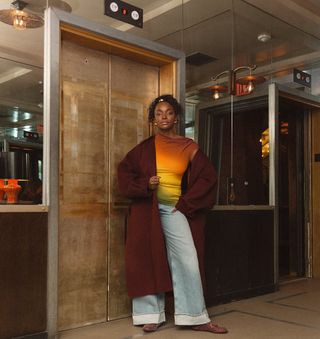 woman wearing cuffed denim outfit with burgundy long coat