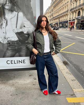 woman wearing cuffed denim outfit with red sneakers