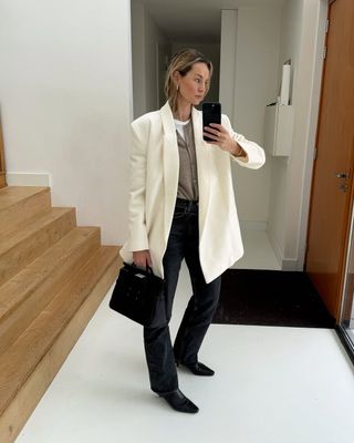 @anoukyve wearing a white blazer with jeans and cardigan