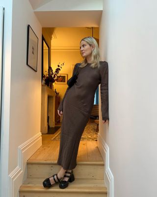 Woman wears brown silk dress and black platform mary janes.