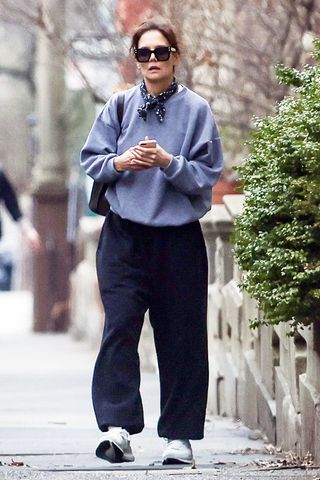 Katie Holmes wearing a sweatshirt, black pants, and sneakers