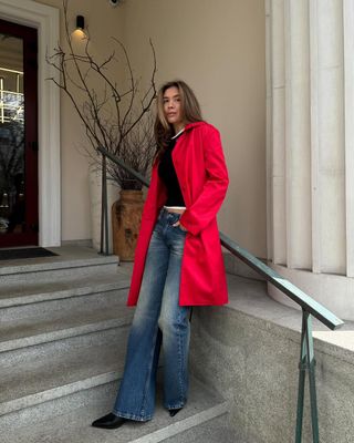 woman wearing flared jeans and red coat