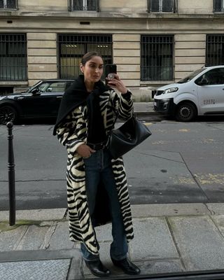 woman wearing flare jeans and zebra long coat