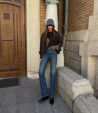 woman wearing flare jeans and leather jacket