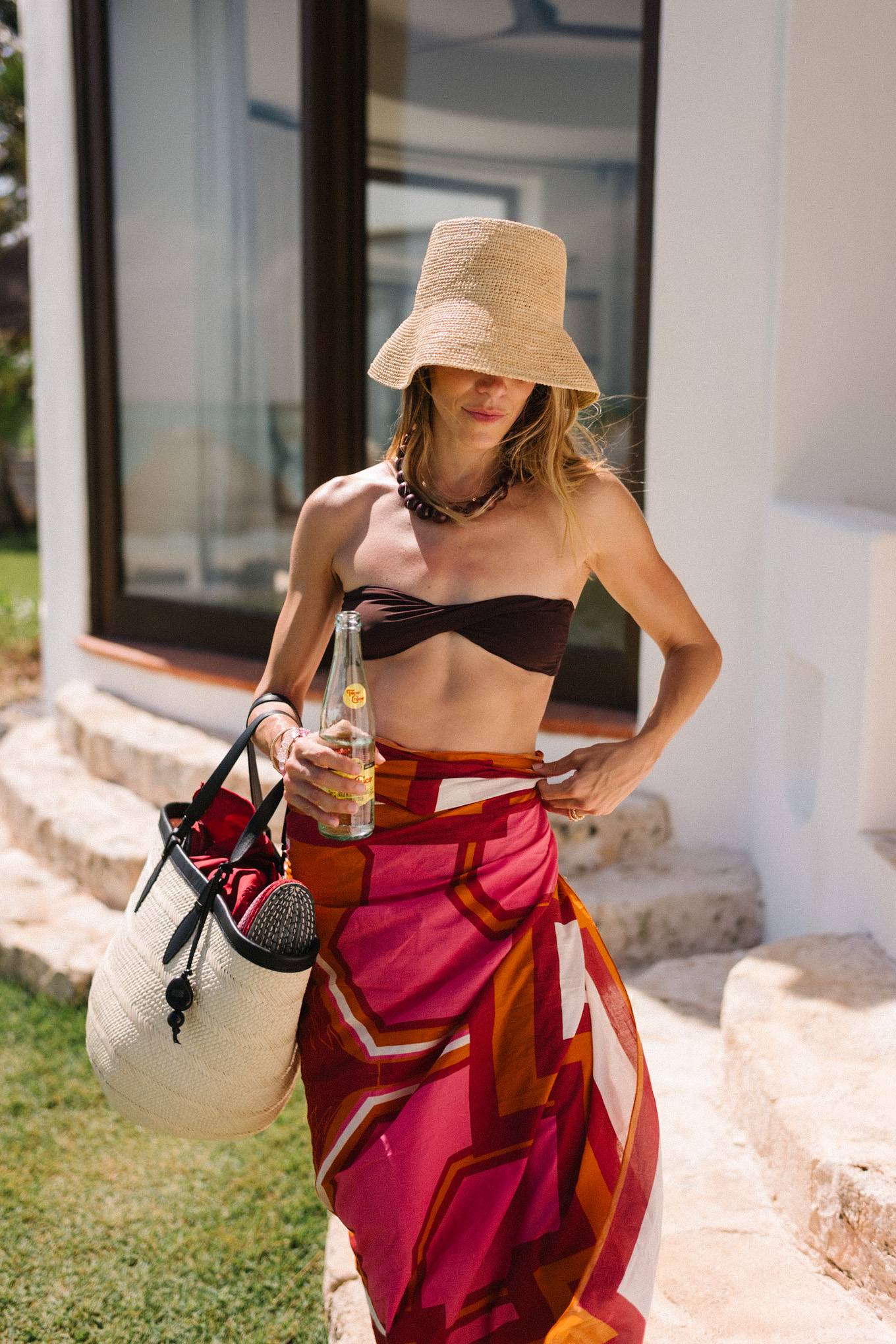 brown bikini straw hat brown bead necklace pink orange pareo