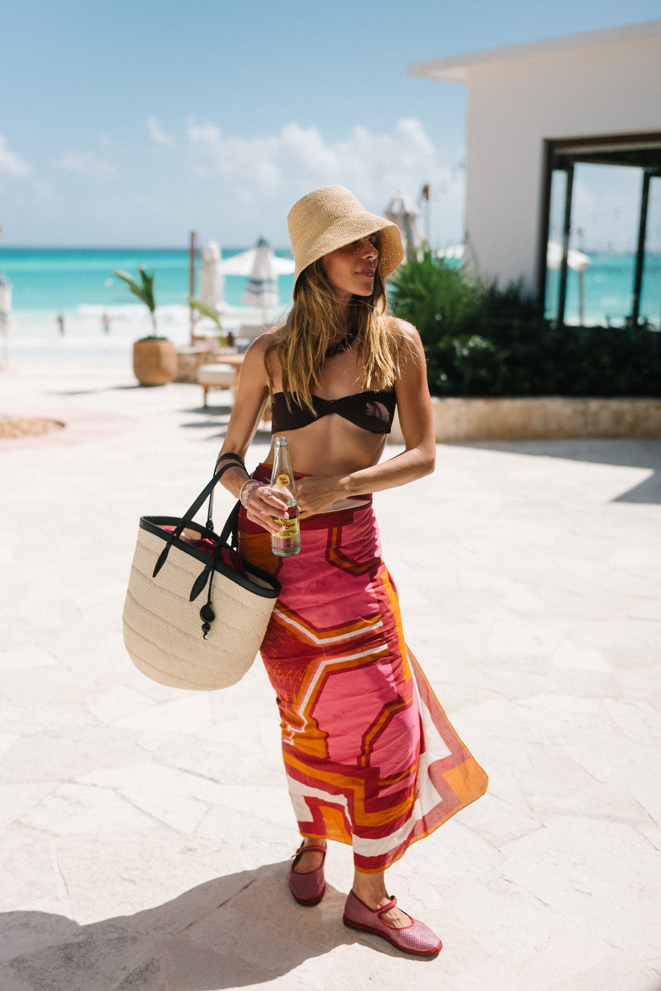 brown bikini straw hat brown bead necklace pink orange pareo