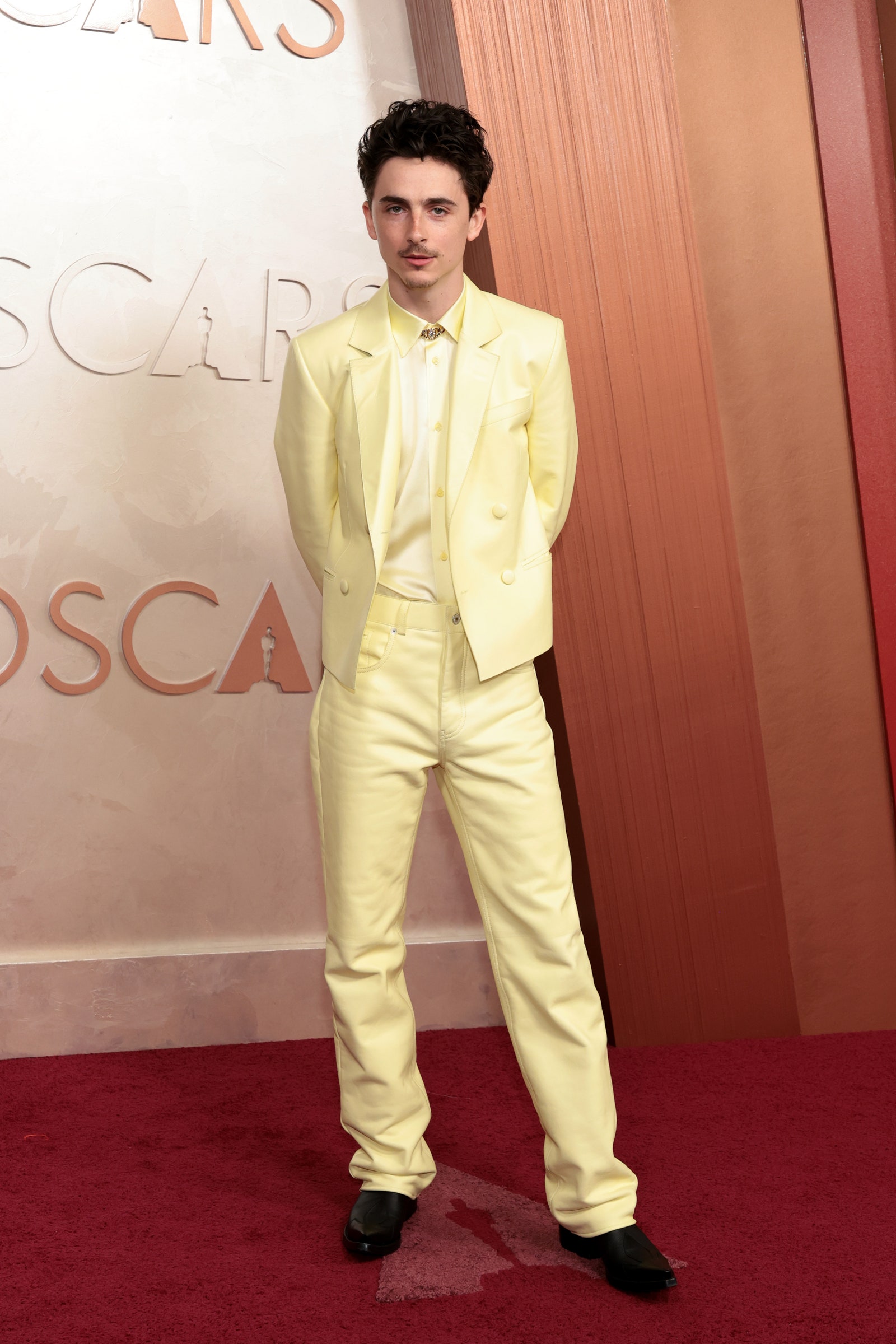 Image may contain Timothe Chalamet Clothing Formal Wear Suit Person Standing Blazer Coat Jacket Adult and Fashion