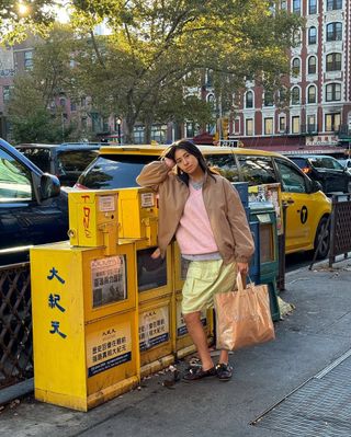 @himichelleli wearing barn jacket, powder pink sweater, lime green skirt, and black sneakers