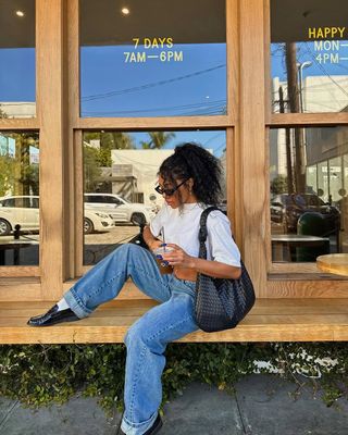 woman wearing white t-shirt with jeans and loafers spring outfit