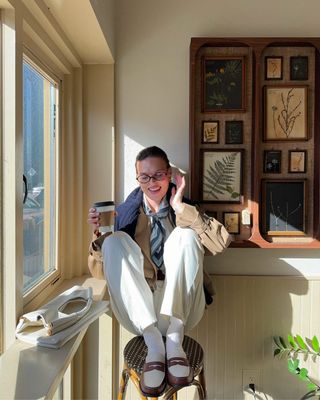 woman wearing tie and white pants with loafers spring outfit