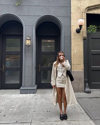 woman wearing vest and mini skirt with loafers spring outfit