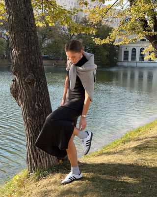 woman wearing black slip dress and sneakers outfit