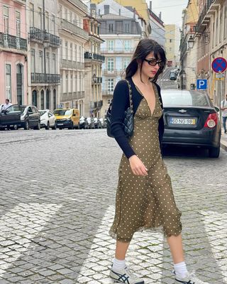 woman wearing polka dot slip dress, cardigan, and sneakers outfit