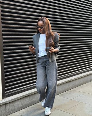 woman wearing white t-shirt and grey jacket and light black jeans