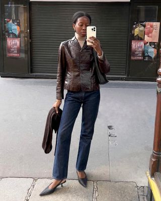 Influencer wears a brown leather jacket.