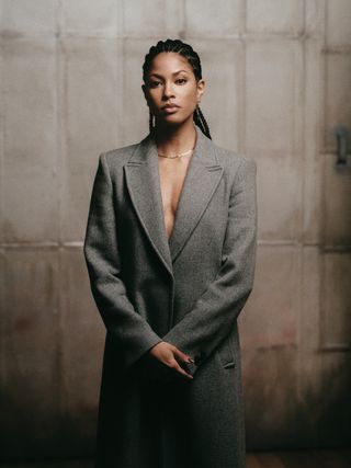 Lex Scott Davis photographed in studio wearing a gray mid-length coat.