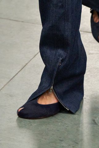 A close up of a pair of navy peep-toe heels from the F/W 25 Tory Burch runway collection.