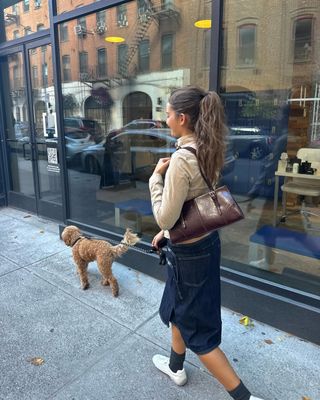 woman wearing white sneakers with long dark denim skirt spring outfit