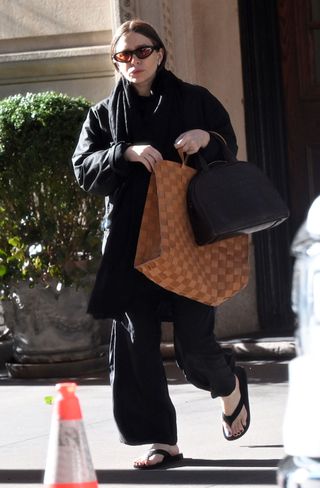 Ashley Olsen wears flip flops and a tote bag by The Row in March 2025