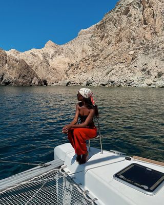 woman wearing red linen pants and head scarf on boat